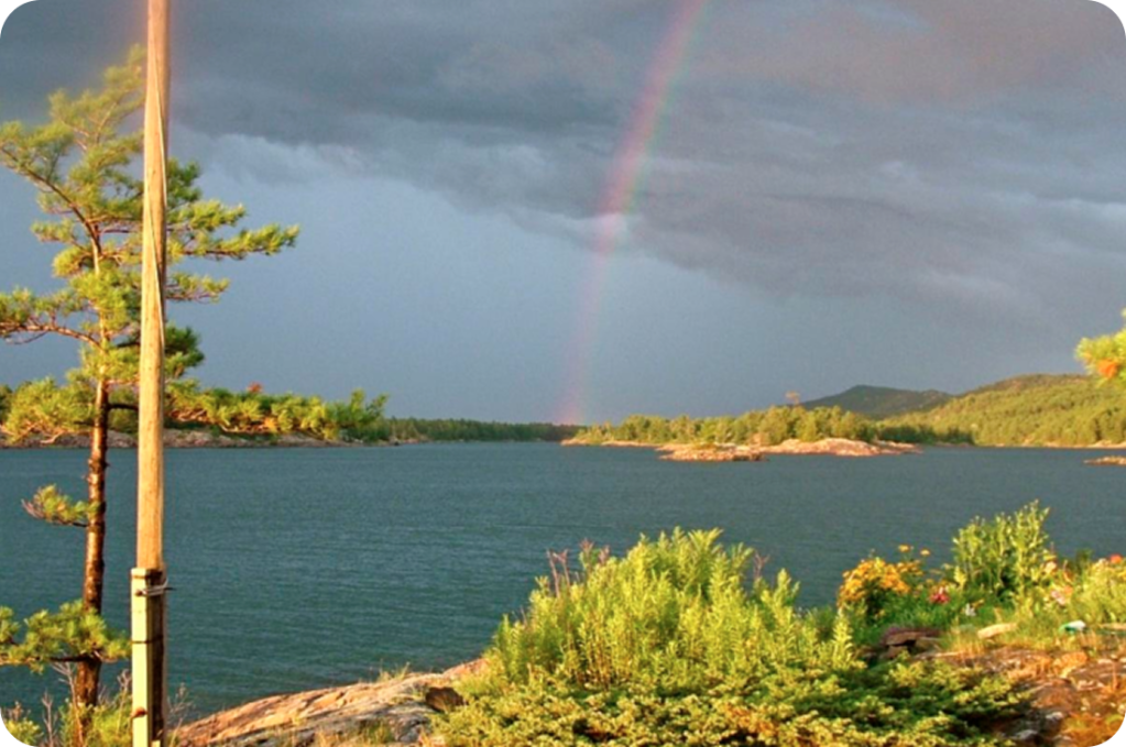 Rainbow over a lake with an island in the foreground